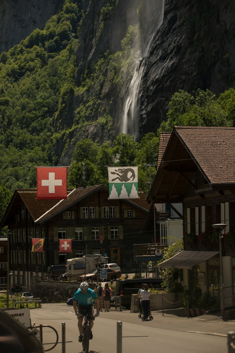 Un ciclista passa davanti a chalet di legno in un villaggio di montagna.
